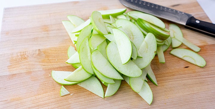 sliced apples for apple crisp recipe on cutting board 