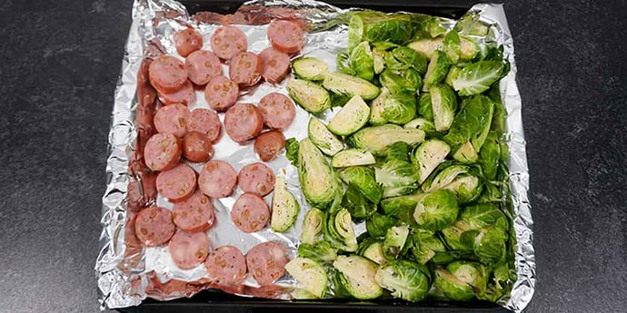 Cut brussels and sausage and place in sheet tray